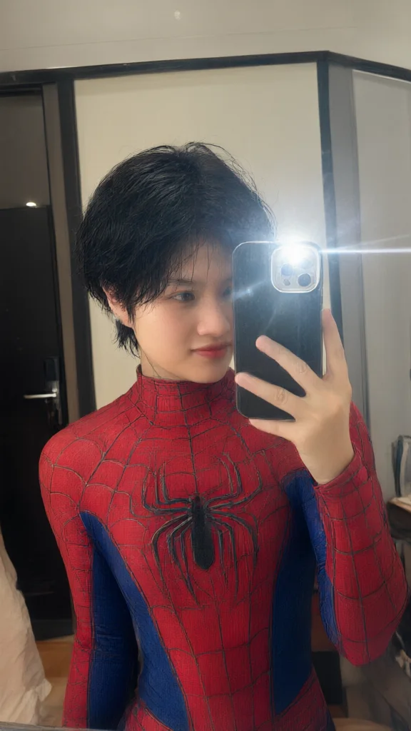 Short hair person in red and blue spider suit taking mirror
