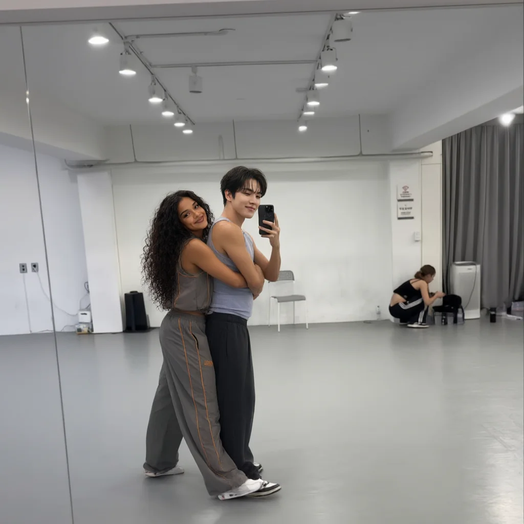Couple taking a mirror selfie in a dance studio with curly