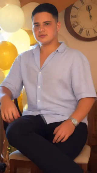 Young man in a light blue shirt sitting with crossed legs