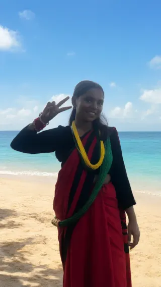 Woman in red sari and yellow garland making a peace sign on