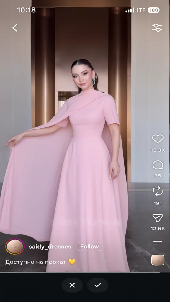 Woman in a long pink dress with short sleeves holding the
